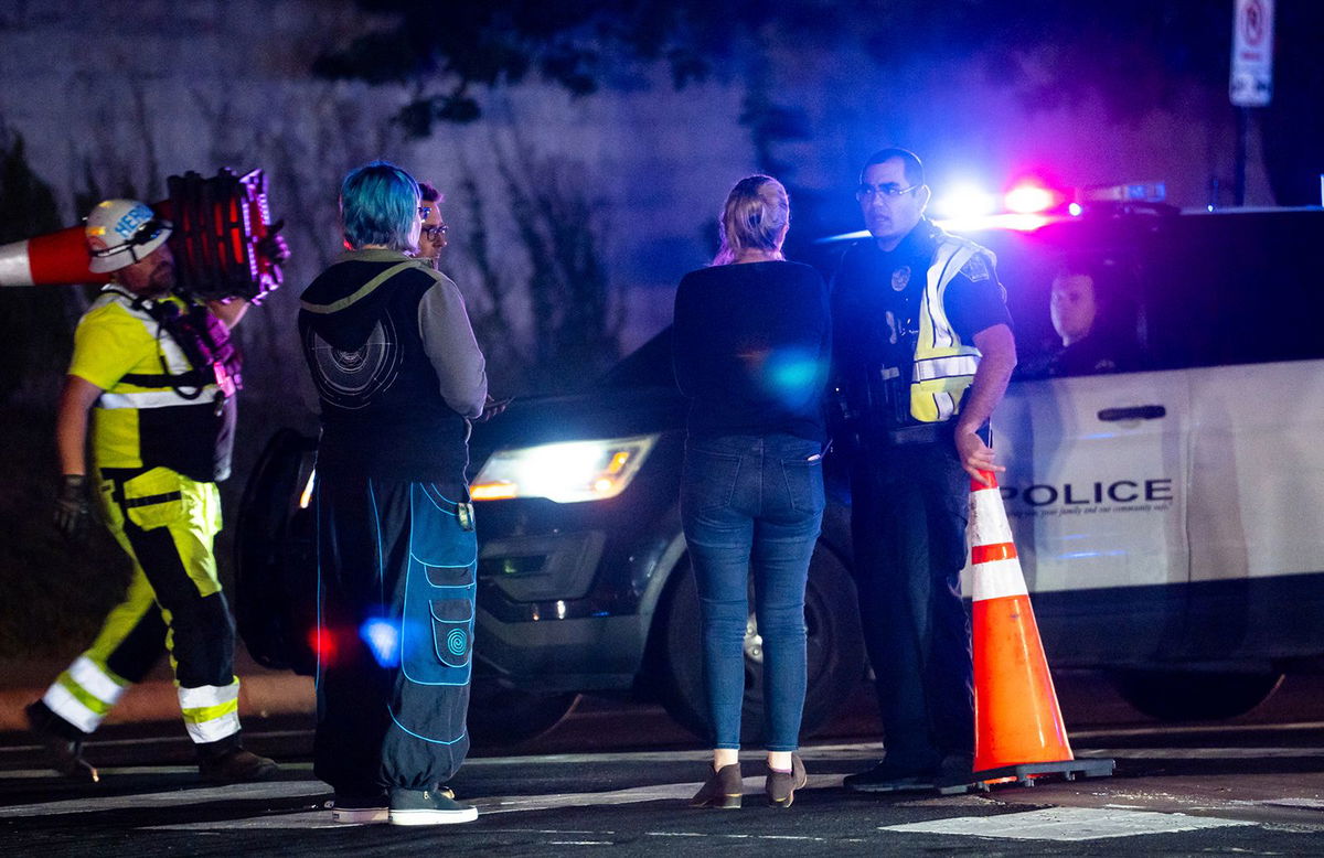 <i>Sara Diggins/AP</i><br/>Neighborhood residents speak to police officers in Austin