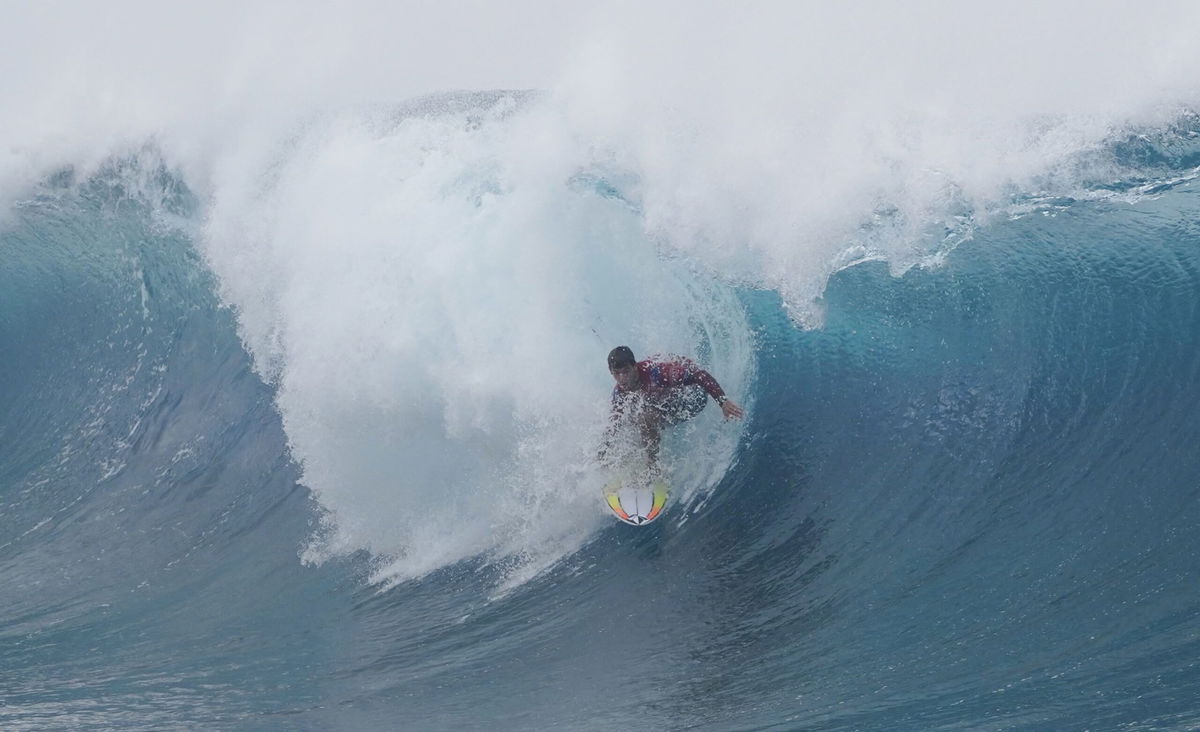 <i>Suliane Favennec/AFP/Getty Images</i><br/>France's Interior Minister Gerald Darmanin (C) sails on the 2024 Olympic Games surfing venue in Teahupoo