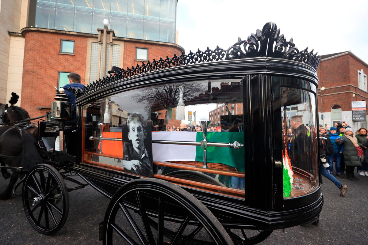 <i>Niall Carson/AP</i><br/>The funeral procession of Shane MacGowan makes its way through the streets of Dublin ahead of his funeral in Tipperary.