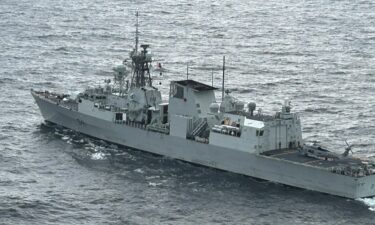 The Canadian frigate HMCS Ottawa is seen from the ship's helicopter as a US Navy helicopter rests on its flight deck in the East China Sea.