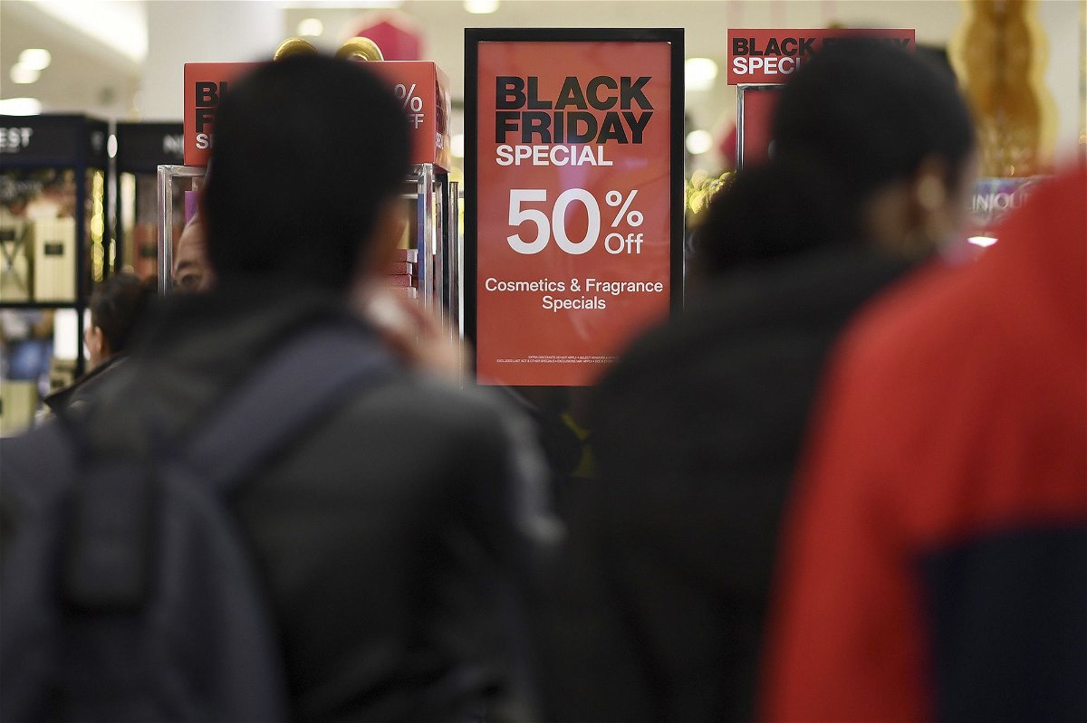 <i>Anthony Behar/Sipa USA/AP</i><br/>People walk past advertised Black Friday discount signs at the Macy's retail store inside the Queens Center Mall