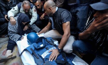 Mourners gather around the body of Al Jazeera cameraman Abu Daqqa on Saturday.