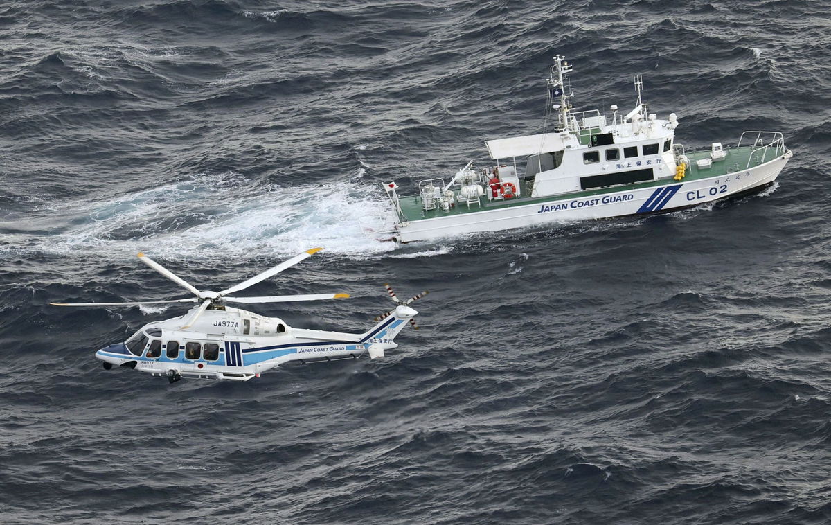 <i>Kyodo/Reuters</i><br/>A Japan Coast Guard vessel and a helicopter conduct a search and rescue operation at the site where a U.S. military aircraft V-22 Osprey crashed into the sea off Yakushima Island