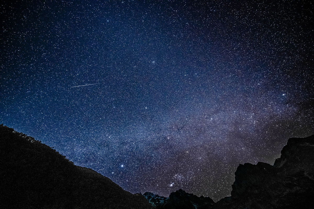 <i>Chine Nouvelle/SIPA/Shutterstock</i><br/>A Geminid meteor is seen streaking across the sky at the Yulong Snow Mountain in southwest China in 2021. This year