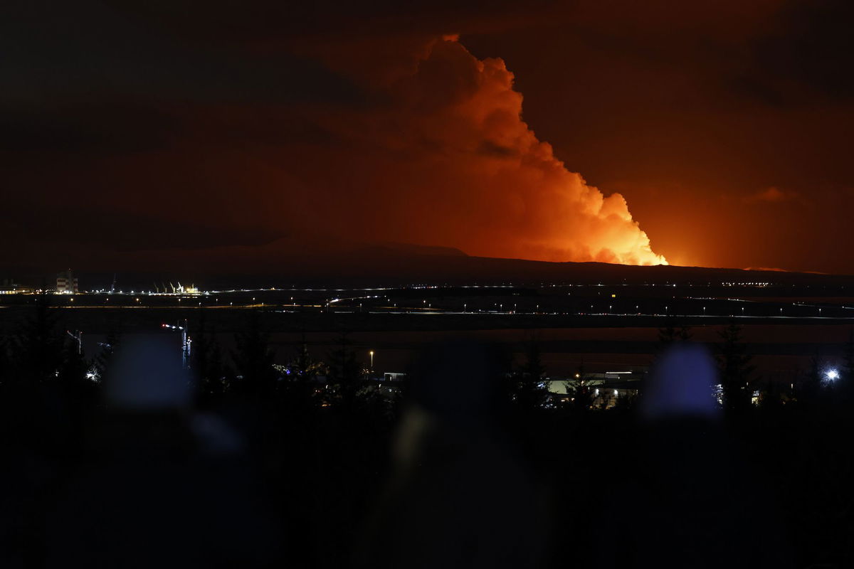 <i>Brynjar Gunnarsson/AP</i><br/>People watch as the night sky is illuminated caused by the eruption of a volcano on the Reykjanes peninsula of south-west Iceland seen from the capital city of Reykjavik