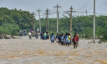 People wade through a flooded road after heavy rains in Thoothukudi on December 20.