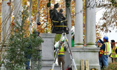 Crews begin the process of removing Confederate statues from a monument in Jacksonville's Springfield Park early Wednesday.