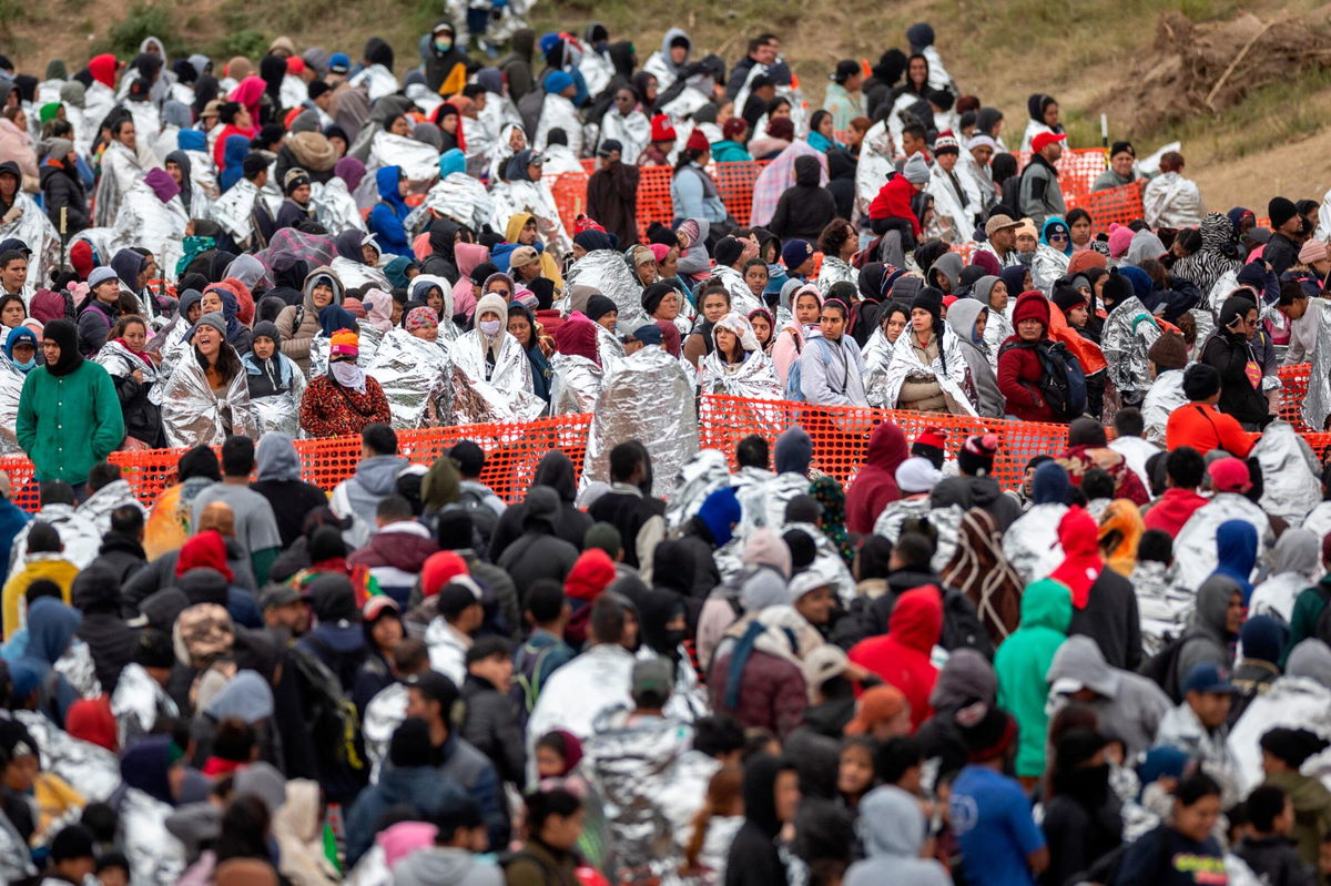 <i>John Moore/Getty Images</i><br/>Immigrants wait to be processed at a U.S. Border Patrol transit center after they crossed the border from Mexico on December 20