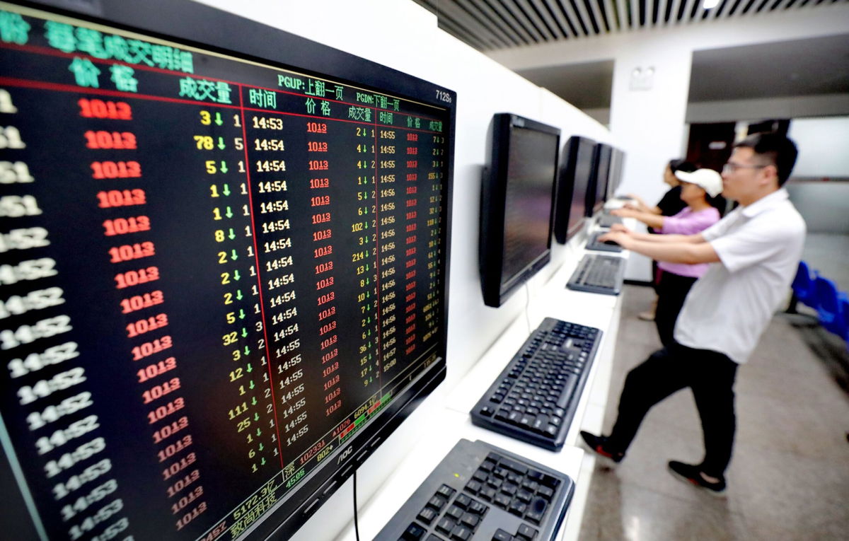 <i>Jiang Sheng/VCG/Getty Images</i><br/>Investors watch computer screens displaying stock price figures at a stock exchange hall on August 28