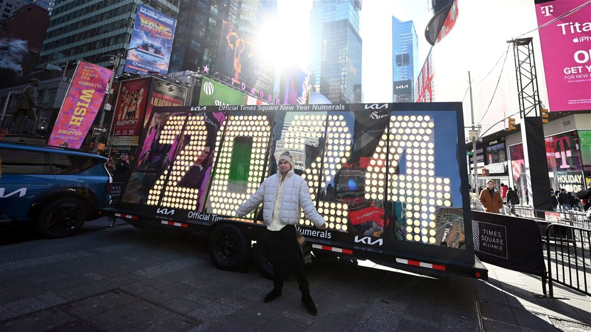 <i>Anthony Behar/Sipa USA via AP</i><br/>People pose in front of the 2024 New Year's Eve numerals after the illumination ceremony in Times Square on December 20.