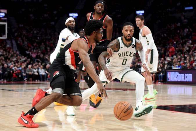 Portland Trail Blazers guard Scoot Henderson, left, drives to the basket against Milwaukee Bucks guard Damian Lillard (0) during the first half of Wednesday night's NBA game in Portland.