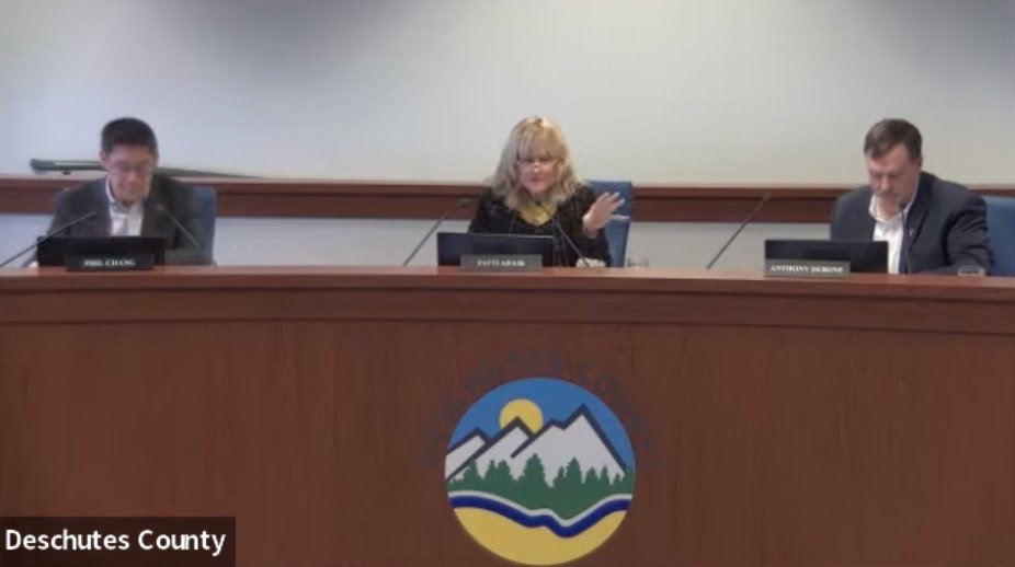 Deschutes County Commission Chair Patti Adair speaks at Wednesday's meeting, flanked by colleague Phil Chang, Tony DeBone