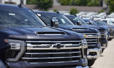 Silverado pickup trucks sit in a long row at a Chevrolet dealership in June. Fourth quarter sales of some GM vehicles