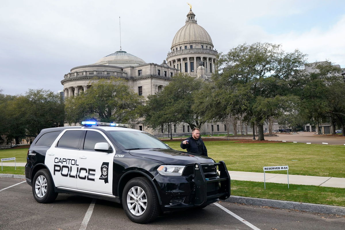 <i>Rogelio V. Solis/AP</i><br/>A Capitol Police officer warns off passersby as they respond to a bomb threat at the Mississippi State Capitol in Jackson on Wednesday morning.