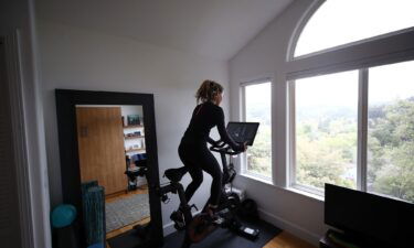 Cari Gundee rides her Peloton exercise bike at her home on April 06