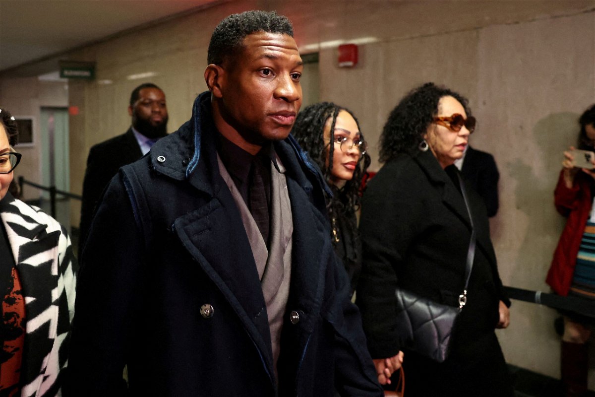 <i>Shannon Stapleton/Reuters</i><br/>Jonathan Majors arrives with Meagan Good to court in New York in December 2023. Majors told ABC that Good has been a source of support to him in recent months