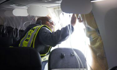 This image from video provided by Elizabeth Le shows passengers near the damage on an Alaska Airlines Boeing 737 Max 9