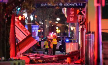 Workers survey damage near the Sandman Signature hotel following an explosion on January 8.