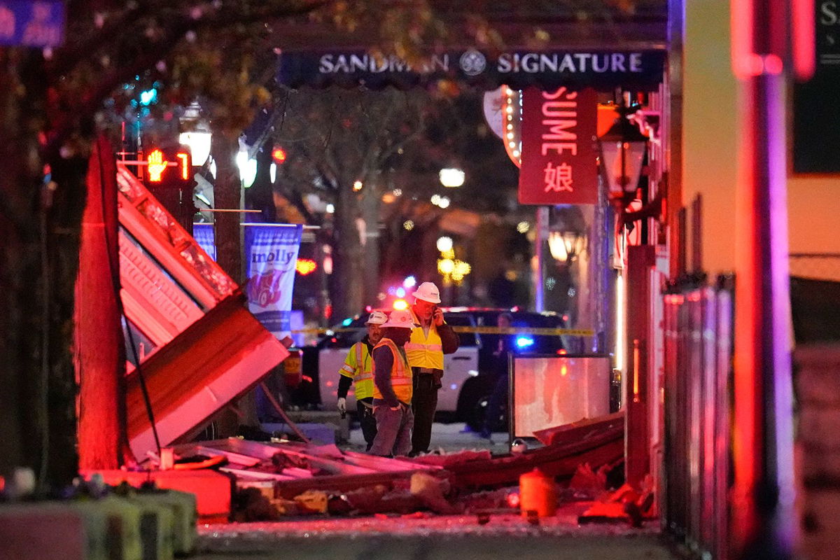 <i>Julio Cortez/AP</i><br/>Workers survey damage near the Sandman Signature hotel following an explosion on January 8.