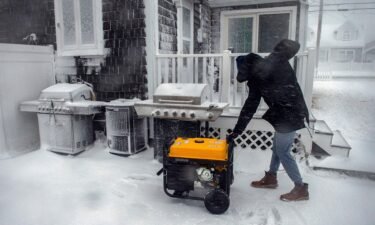 A man starts a generator at his home after losing power during a snow storm in Marshfield