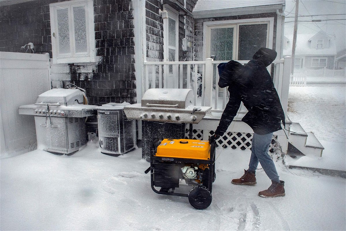 <i>Joseph Prezioso/AFP/Getty Images</i><br/>A man starts a generator at his home after losing power during a snow storm in Marshfield