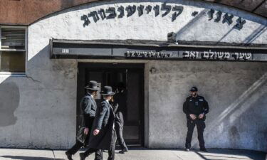 A member of the New York Police Department patrols in front of a synagogue on October 13