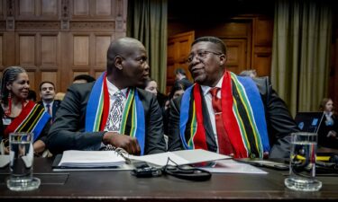 People sit inside the International Court of Justice (ICJ) on the day of the trial to hear a request for emergency measures by South Africa