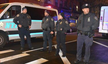 Police officers stand guard on a road after an assailant attacked three NYPD officers with a machete during the new year celebrations in New York on December 31
