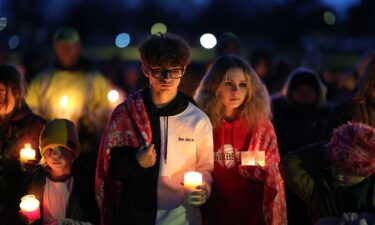 A man and children leave the McCreary Community Building after reuniting Thursday following a shooting at Perry High School near Des Moines