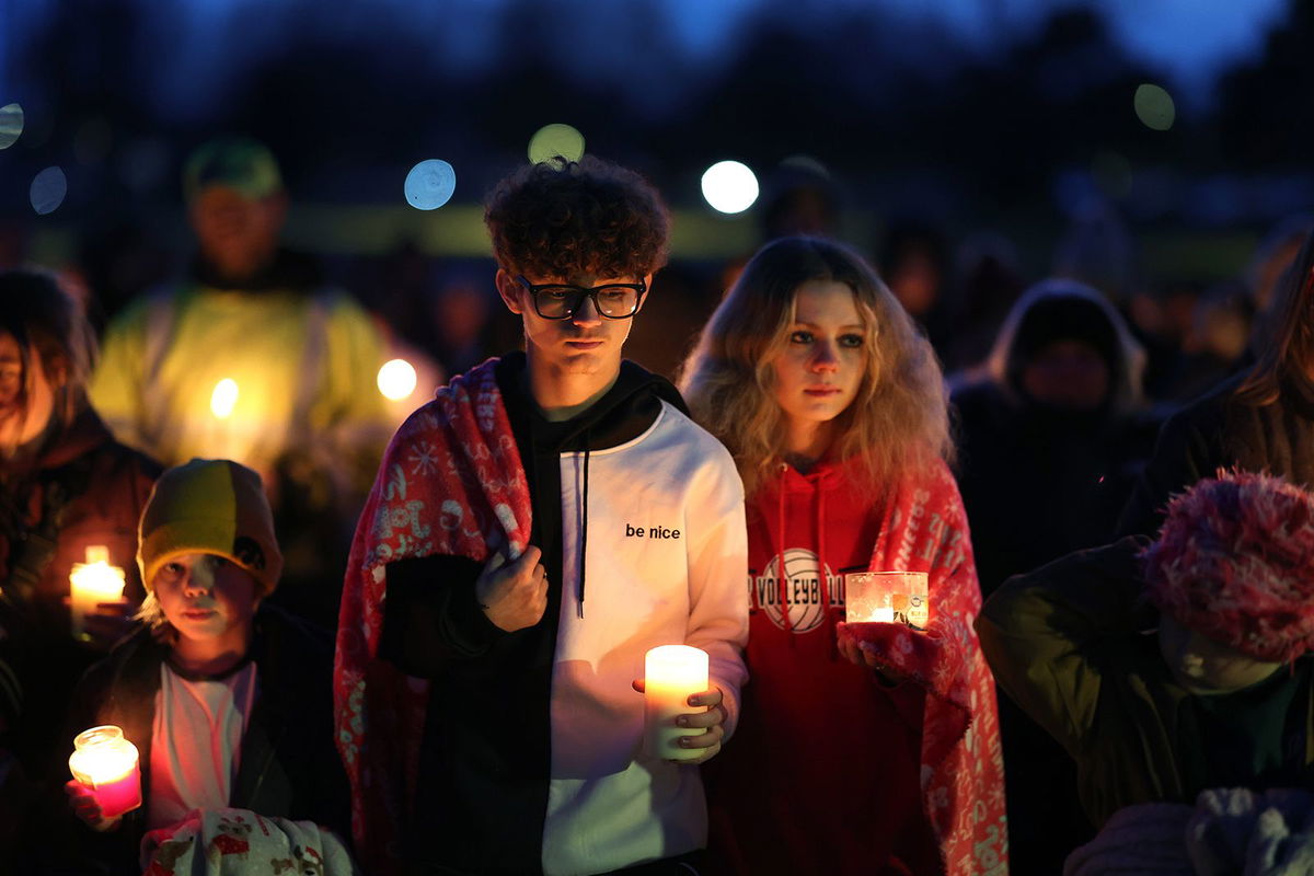 <i>Charlie Neibergall/AP</i><br/>A man and children leave the McCreary Community Building after reuniting Thursday following a shooting at Perry High School near Des Moines