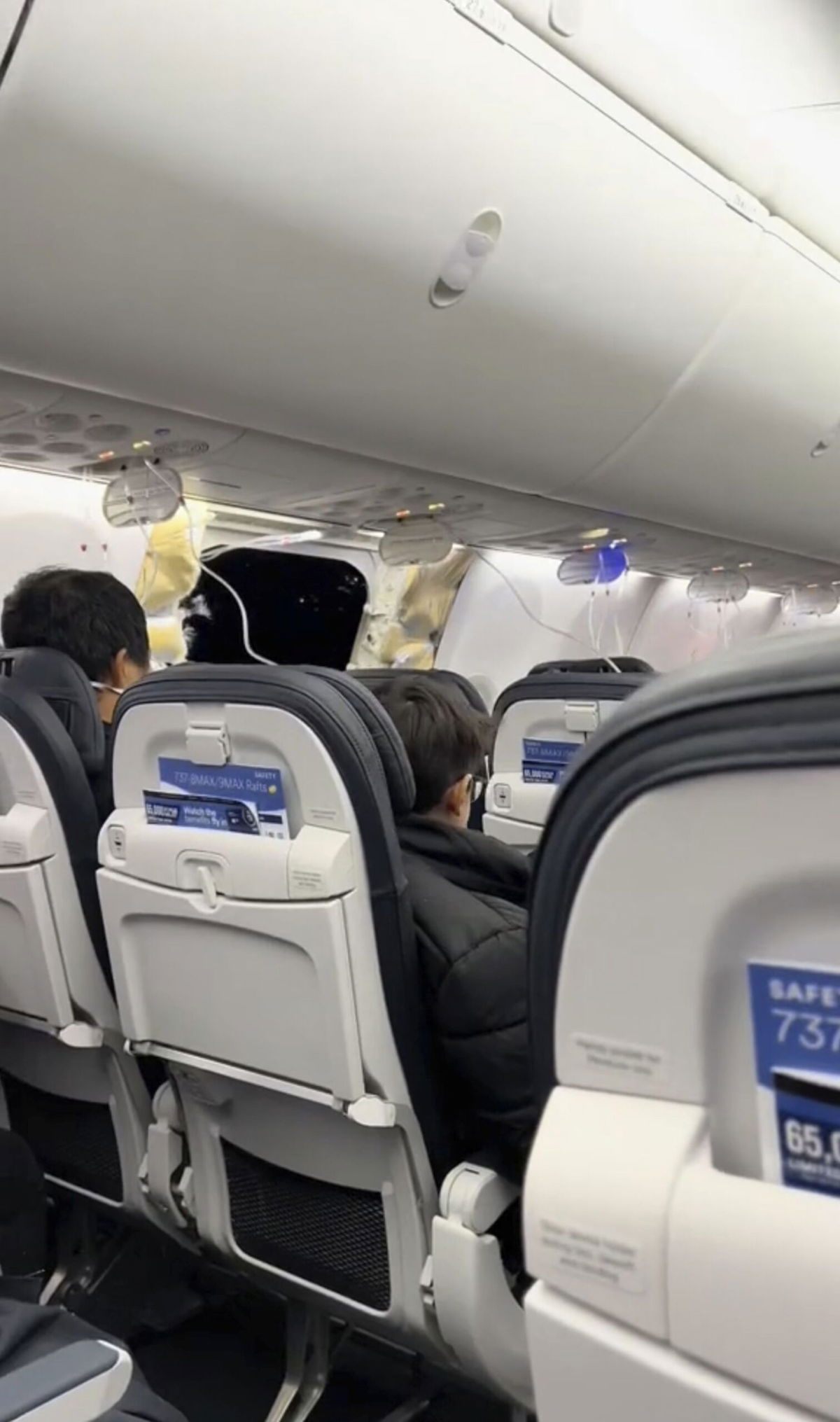 <i>Elizabeth Le via AP</i><br/>This image from video provided by Elizabeth Le shows passengers near the damage on an Alaska Airlines Boeing 737 Max 9