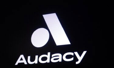 A screen displays the company logo for Audacy