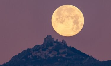The wolf moon can be seen setting behind the castle of Rocca Calascio in the Abruzzo region of Italy