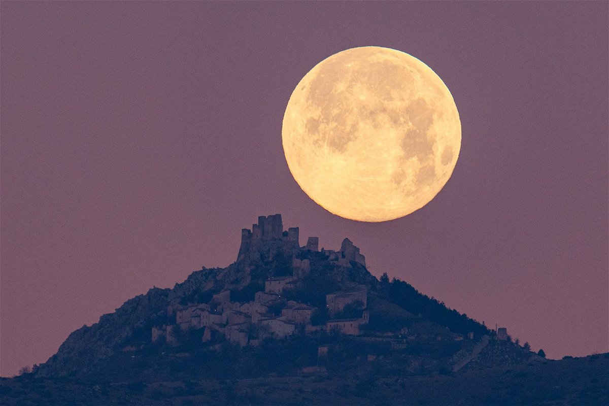 <i>Lorenzo Di Cola/NurPhoto/Getty Images</i><br/>The wolf moon can be seen setting behind the castle of Rocca Calascio in the Abruzzo region of Italy