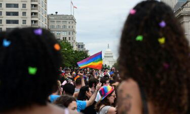 The US Capitol building is seen in the background as people attend a LGBTQ + Pride event in Washington