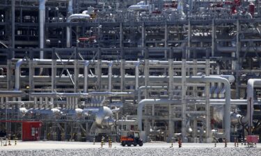 A small vehicle drives past a network of piping that makes up pieces of a "train" at Cameron LNG export facility in Hackberry