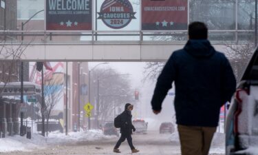 People walk across the street in downtown Des Moines on January 13. Iowa Republicans who are willing to brave record-low temperatures are set to kick off the party’s 2024 presidential nominating process with Monday night’s caucuses.