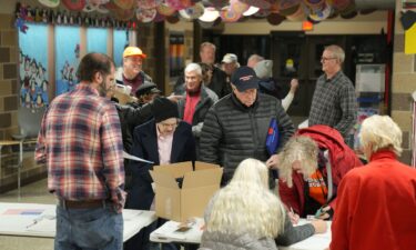 People arrive at a caucus site at Fellows Elementary School as voters get ready to choose a Republican presidential candidate in Ames