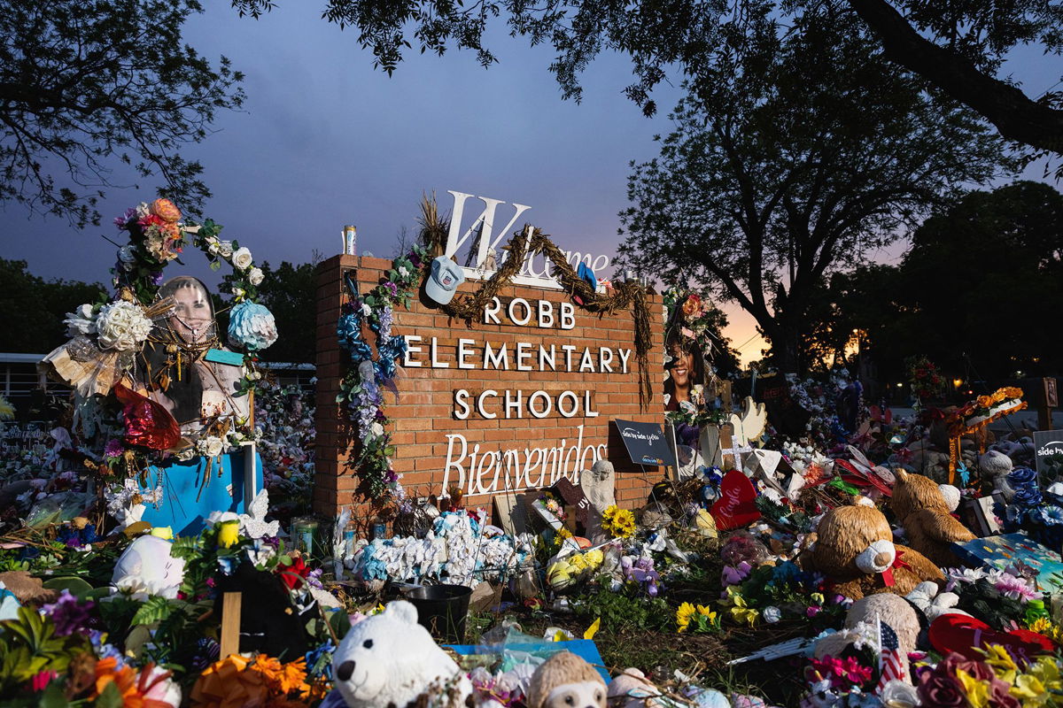 <i>Jordan Vonderhaar/Getty Images</i><br/>The sun sets behind the memorial for the victims of the massacre at Robb Elementary School on August 24