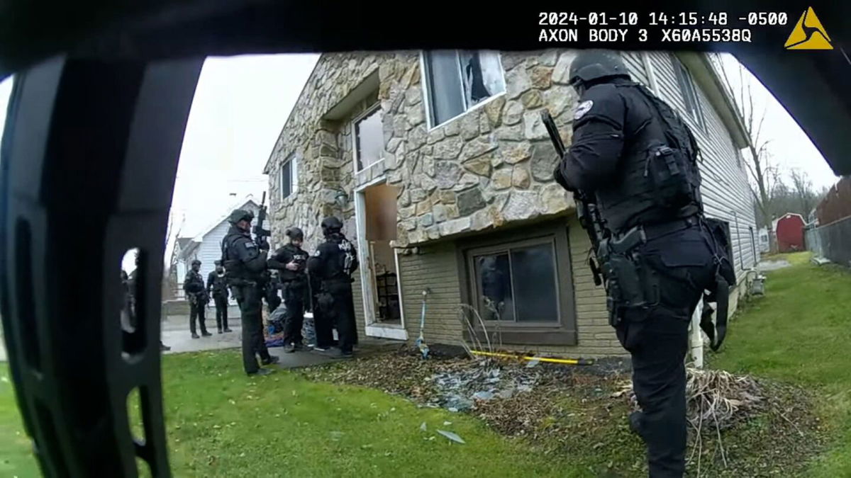 <i>City of Elyria</i><br/>A body-worn camera footage still shows Elyria Police Department officers gathered outside a home during a raid on January 10.
