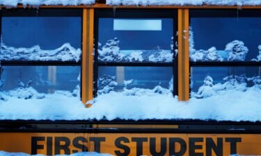 A snow covered school bus sits in a parking lot in Wheeling