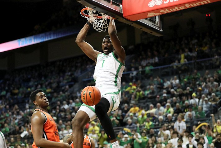 Oregon center N'Faly Dante (1) dunks next to Oregon State center KC Ibekwe during the first half of an NCAA college basketball game Wednesday in Eugene