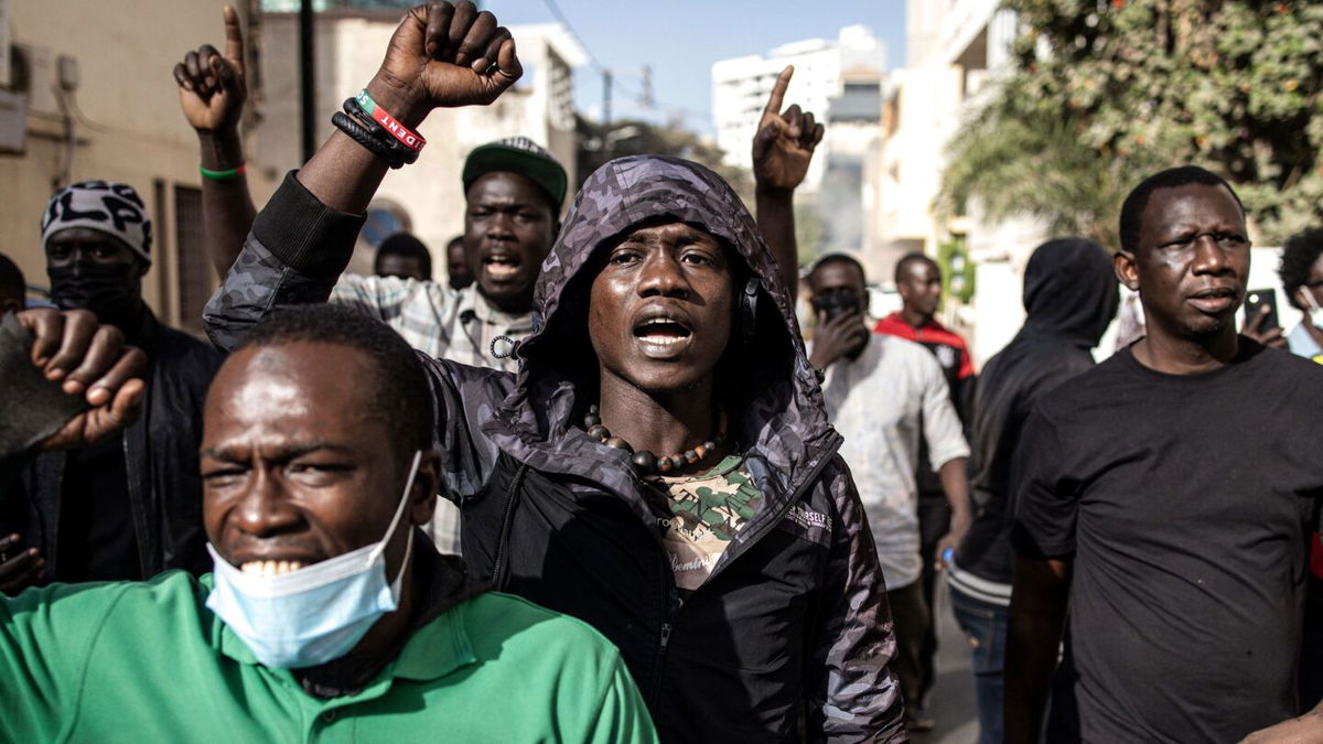 <i>Seyllou/AFP via Getty Images</i><br/>An opposition supporter reacts in front of a burning barricade during demonstrations called by the opposition parties in Dakar on February 4.