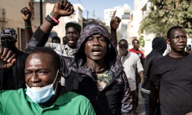 An opposition supporter reacts in front of a burning barricade during demonstrations called by the opposition parties in Dakar on February 4.