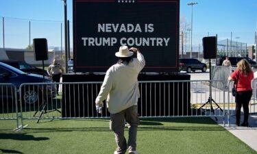 A person takes a picture of a screen before former President Donald Trump speaks at a campaign event in Las Vegas on January 27