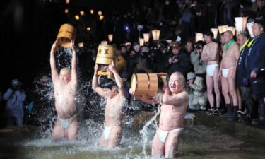 Participants purify themselves with cold water on Yamauchigawa river during Somin-sai festival at Kokusekiji Temple in Iwate prefecture