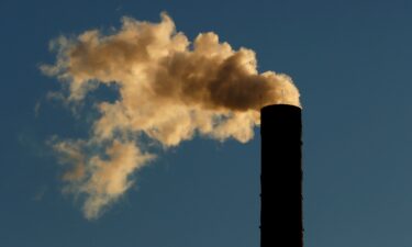 A smoke stack on a building as the sun rises on January 27