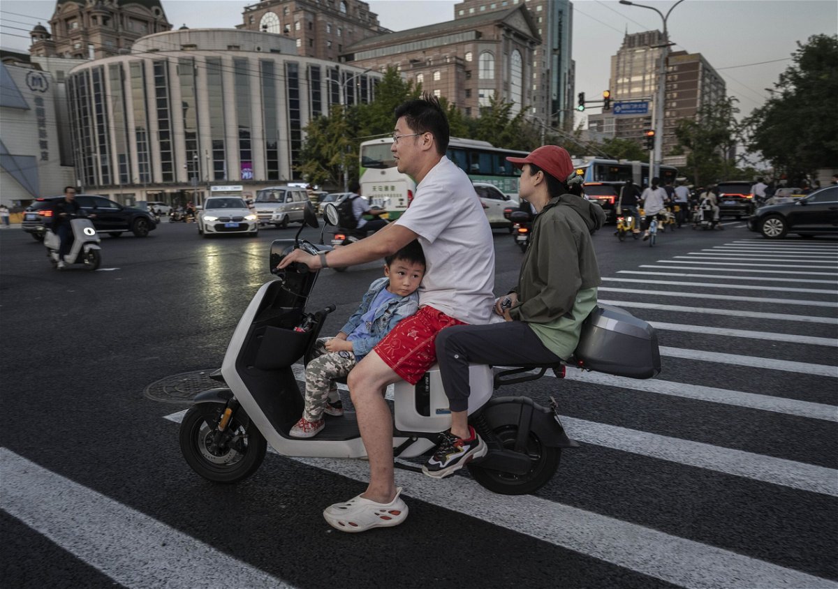<i>Kevin Frayer/Getty Images via CNN Newsource</i><br/>A boy riding with his parents on a scooter in Beijing
