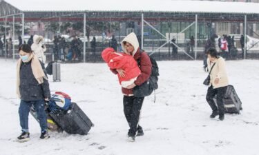 Travelers pull luggage through snow at Luohe Railway Station in Henan province on February 2.