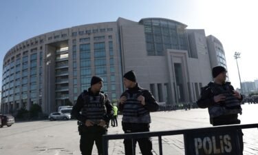 Police officers stand guard outside the Caglayan courthouse after a shooting in Istanbul.